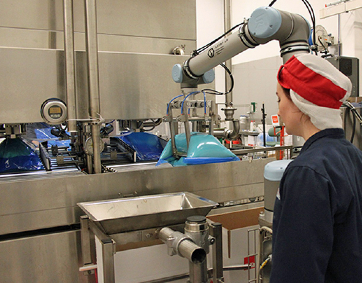 After grabbing foodservice-style bags of vanilla cream product from the filling system, the cobot inserts the product one bag at a time into cases. The payback time of the investment in the cobot is about six months, says Johan Linn&eacute;, site manager.