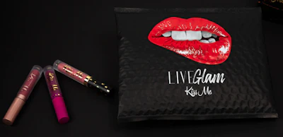 Members of LiveGlam's Lippie Club receive their monthly trio of lippies products in a black-matte plastic bubble mailer emblazoned with an illustration of a pair of fantastically shiny red lips in the midst of a seductive bite.