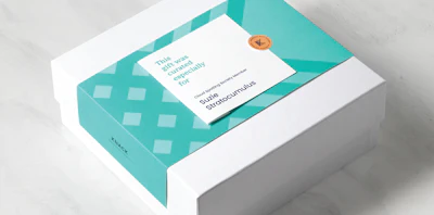 The belly band holding the gift card only is affixed to the lid, not the bottom portion of the gift carton. This allows a single belly band size to accommodate different carton heights/depths, as long as the lid is the same size.