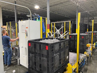 The reusable bins hold piles of PET preforms that in some cases need to be leveled before the lid can be placed.