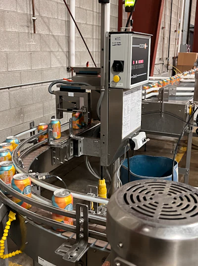 Custom conveyance brings the two Wild Goose lines together and sends cans through a Heuft Basic low fill/low pressure detector.