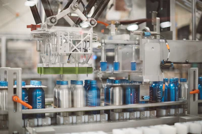 A custom, Sherpa-engineered applicator applies a Fishbone carrier to the top of a six-pack of bottles.