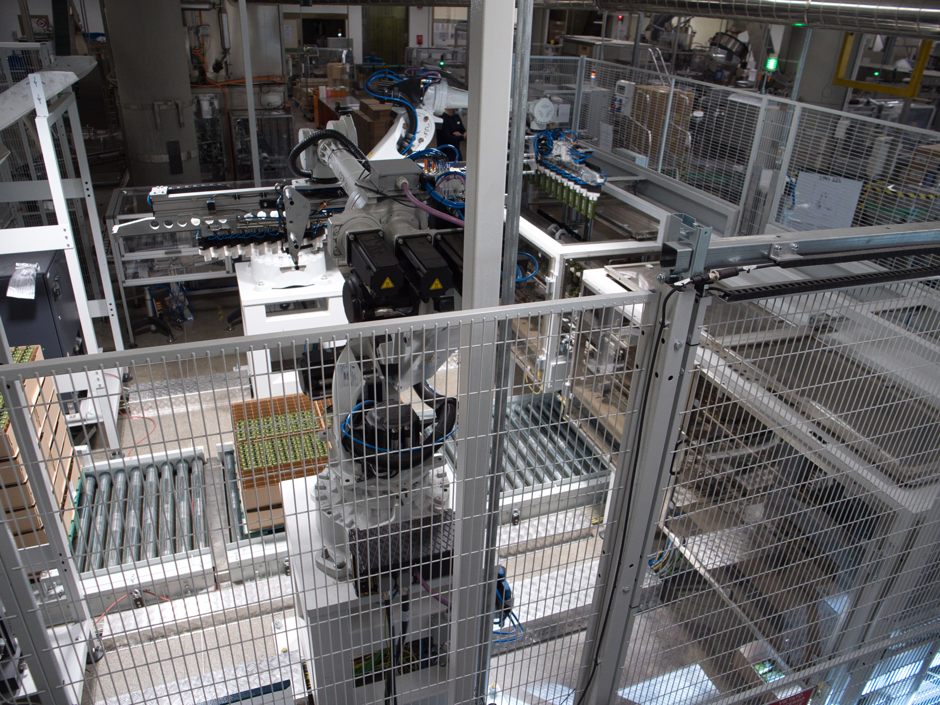 With the help of special grippers and high-resolution 2D cameras, the two NJ-40 articulated robots pick a series of bottles from the partitioned cases used for shipping.