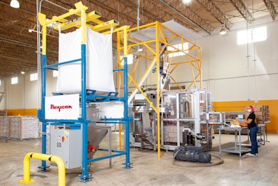 The bulk bag discharger unloads ground coffee into a floor hopper, charging a flexible screw conveyor that feeds the packaging machine.