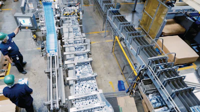 Infeed of 5-oz and 7-oz canned and glue-applied labeled product into the cartoner at the Santa Fe, Calif. Bumble Bee facility. Note the layout of three parallel tracks, with product first entering the space and feeding the cartoner on the center track. After product is cartoned and laned, it turns sharply 180 deg, carrying product downstream while parallel to the cartoner. Product then takes another, wider 180-deg turn around the cartoner, and finally travels parallel to the previous two tracks again for tray packing.
