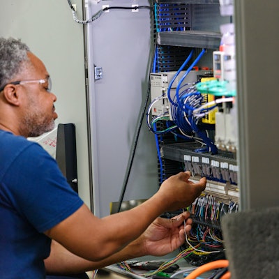 Carlos Gaiter, electrical engineer, wiring a panel on a servo drop packer.