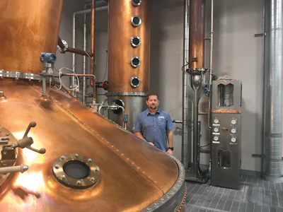 Head Distiller Greg Eidam stands next to the country’s largest pot still located in Kodak, Tenn. The pot still was designed to handle growing sales of Roaming Man Whiskey.