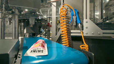 A flavored water product in an SUP exits one of TopPop’s six rotary pouch machines.