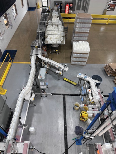 Unscrambling operations at the start of the line upright and orient loose 2.5-gal HDPE bottles out of a hopper. The line is mirrored after a single unscrambling unit, but only one line is regularly in use until production ramps up to expected future volumes.