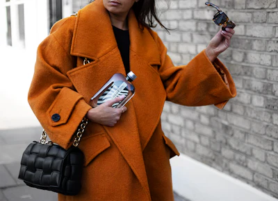 The flask-like bottle features a flat, ergonomic shape that enables it to fit easily into small spaces such as crossbody bags, back pockets, and seat-back storage on trains and planes.