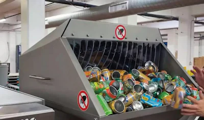 Empty, damaged cans are fed by hand into the Weima E.200.