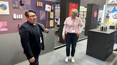 Melichar (left) and Andrea Wecke, Gmund, discuss paper alternatives from sources like grass and hemp.