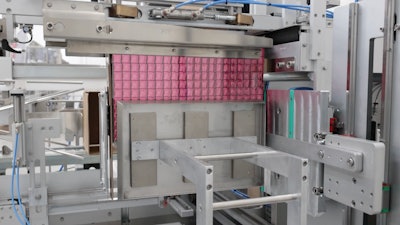 The 240-ct cube of cartoned mascara tubes is pushed or side loaded into a waiting erected case.
