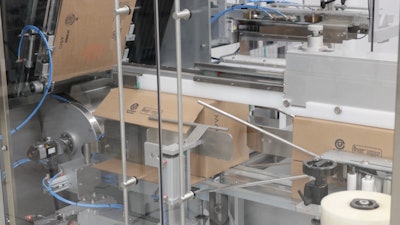 Side-load case packing happens after the case is erected and bottom flaps are tapled closed. Once packed with 240 cartons, the top flaps are closed and the finished cases leave the line. Palletizing is manual at this pace.