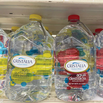 Multiple varieties of Cristalia water on a retail shelf. While a gallon is equivalent to 128 oz, 120-oz jugs (near gallon equivalent) are the standard in Puerto Rico.