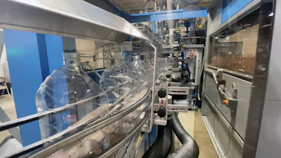 Blown bottles exit the blow molder on Dyco conveyers.