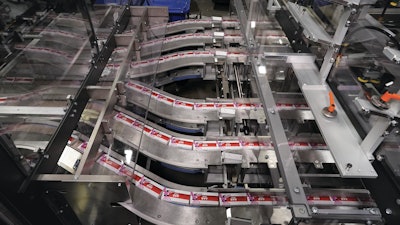 Cartons are picked and placed by an Aagard delta-style robot six at a time onto these conveyor belts VIDEO TIME STAMP 1:30 that lead to the sleever.
