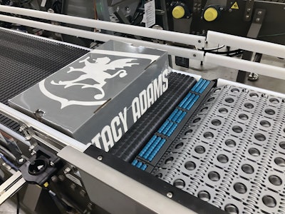 Closeup shows one boxed pair moving from right to left. The gray belting is Activated Roller Belt (ARB), which manipulates the movement and orientation of the boxes so that they are all left-justified.