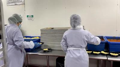 Manually portioning meals into two-compartment trays limited throughput to around 10–15 trays per minute per line.