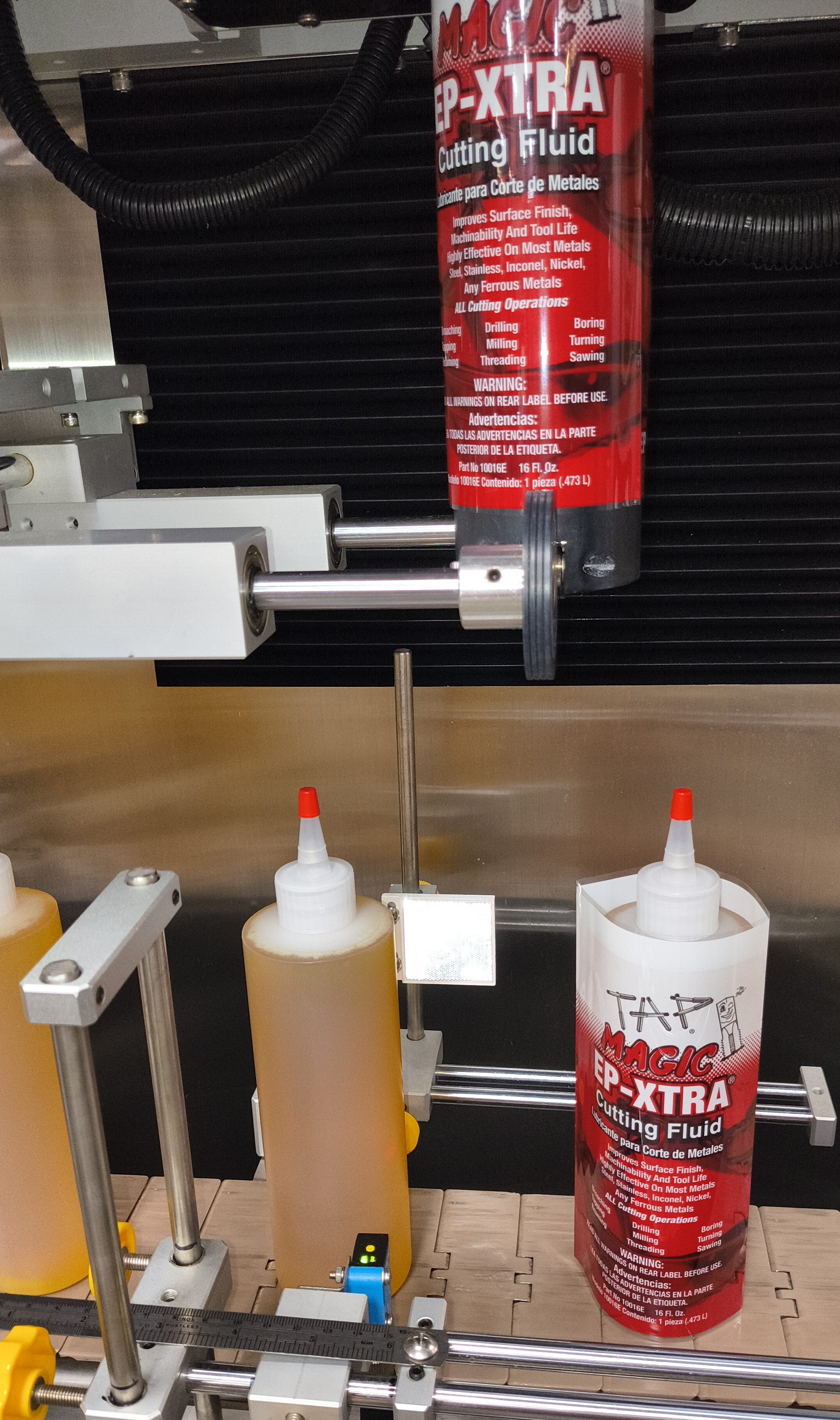 16-oz HDPE bottle in productionat Tap Magic: Application of a shrink sleeve on the Sleeve Seal machine.