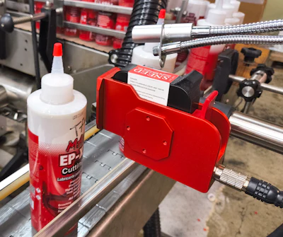 Lot and date code information is printed on the labeled container by this ink-jet printer.