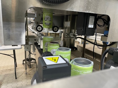 Shrink sleeves being 'shot' onto awaiting bright cans, pictured here traveling into the steam tunnel.