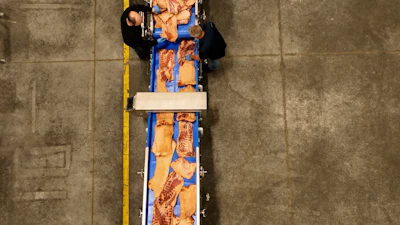 Slices of pork belly pass through a metal detector.