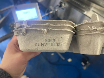 The side of each carton gets a clean, readable lot and date code.