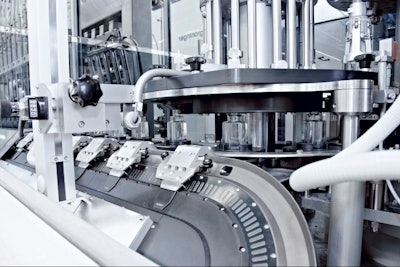 The oval-shaped linear track of the Beckhoff XTS is tilted by 45 degrees relative to the plane on which pucks deliver bottles to a capping station.